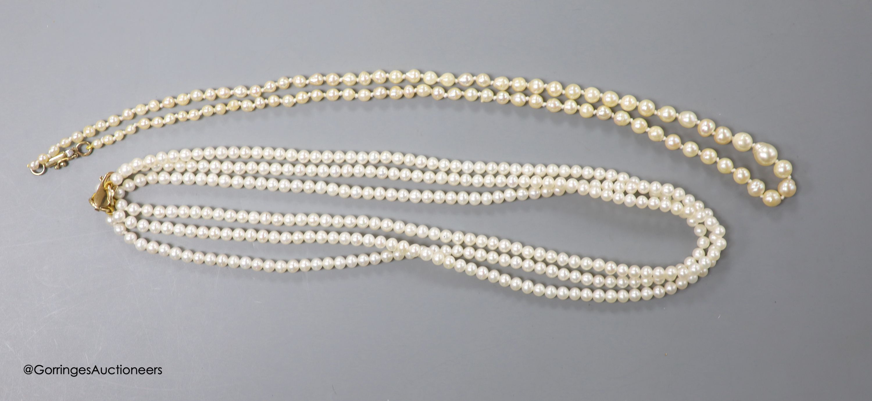 A triple strand cultured pearl choker necklace, with 375 clasp, 40cm and a single strand graduated baroque pearl necklace, with 9kt clasp, 48cm.